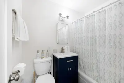 a bathroom with a toilet and a sink and a mirror at Cozy House Minutes From Downtown in Los Angeles