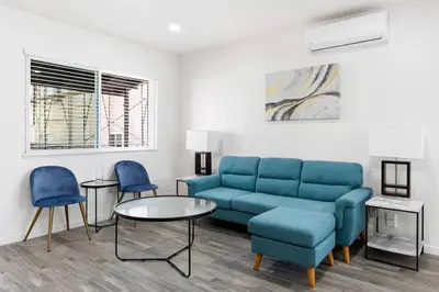 a living room with a blue couch and two chairs at Cozy House Minutes From Downtown in Los Angeles