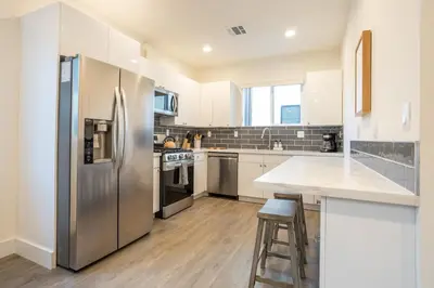 a large kitchen with a stainless steel refrigerator at LA Cityscapes in Los Angeles
