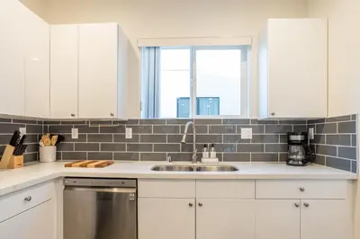 a kitchen with white cabinets and a sink at LA Cityscapes in Los Angeles