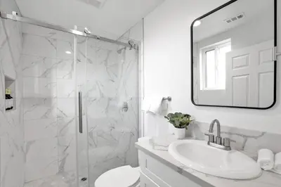 a white bathroom with a shower and a sink at Luxe Townhouse Near Downtown LA in Los Angeles