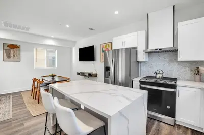 a kitchen with white cabinets and a white counter top at Luxe Townhouse Near Downtown LA in Los Angeles