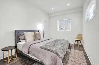 a white bedroom with a large bed and a table at Luxe Townhouse Near Downtown LA in Los Angeles