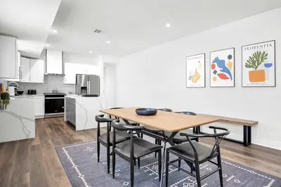 a kitchen and dining room with a wooden table and chairs at Spectacular Rooftop View House in Los Angeles