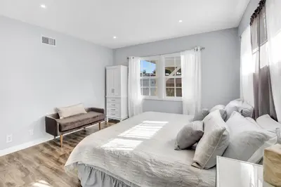 a white bedroom with a large bed and a chair at Valley Ranch With Pool in Los Angeles