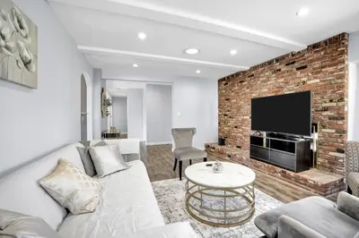a living room with a white couch and a brick wall at Valley Ranch With Pool in Los Angeles