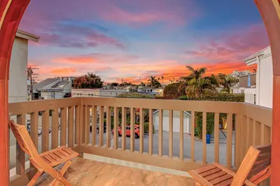 a balcony with two chairs and a sunset at Venice Beach Villa in Los Angeles