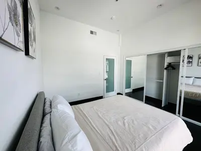 a white room with a bed and a couch at Cool Apartment in West Hollywood in Los Angeles