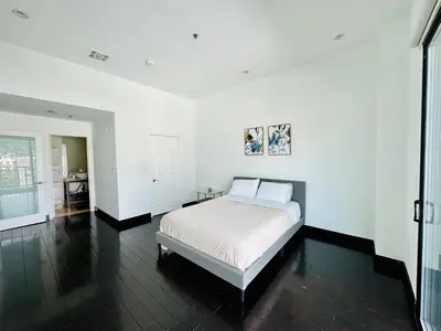 a white bedroom with a bed and a table at Cool Apartment in West Hollywood in Los Angeles