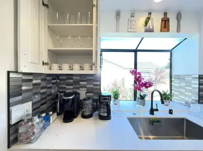 a kitchen with a sink and a counter top at New Charming Spacious Disneyland Pool Home in Garden Grove