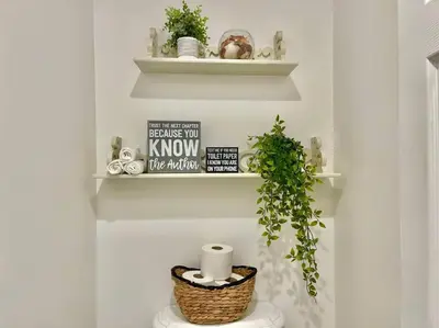 a bathroom with a toilet with a plant and shelves at New Charming Spacious Disneyland Pool Home in Garden Grove