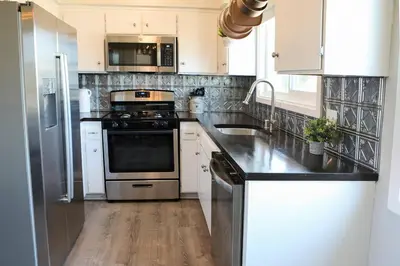 a kitchen with stainless steel appliances and white cabinets at GREAT VIEWS - Over the Oaks - Stylish - Whole Home in Thousand Oaks