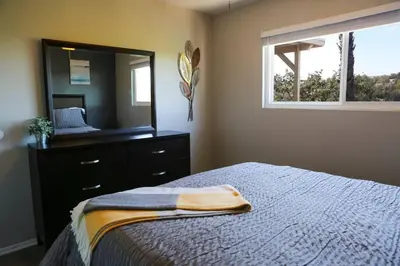 a bedroom with a bed with a dresser and a mirror at GREAT VIEWS - Over the Oaks - Stylish - Whole Home in Thousand Oaks