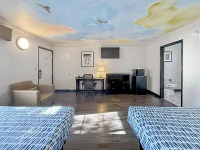 a room with two beds and a table with birds on the ceiling at Super 7 Motel - Anaheim Packing District & Disneyland in Anaheim