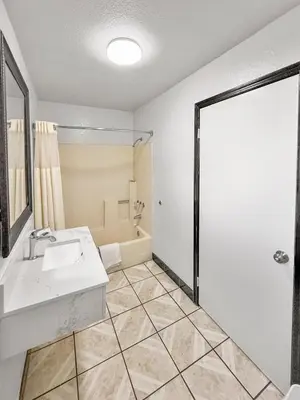 a bathroom with a white sink and a shower at Super 7 Motel - Anaheim Packing District & Disneyland in Anaheim