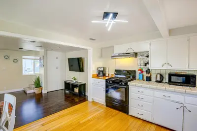 a kitchen with white cabinets and a stove top oven at 2 Mi to Ocean Long Beach Home with Gas Grill! in Long Beach