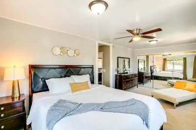 a bedroom with a large bed with a ceiling fan at 2 Mi to Ocean Long Beach Home with Gas Grill! in Long Beach