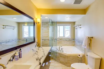 a bathroom with a tub and a toilet and a sink at 2 Mi to Ocean Long Beach Home with Gas Grill! in Long Beach