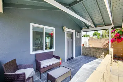 a patio with two chairs and a window on a house at 2 Mi to Ocean Long Beach Home with Gas Grill! in Long Beach