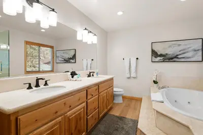 a bathroom with two sinks and a tub and a toilet at Arctic Wolf at Summit Base - 4 Bedroom log cabin at the base of Snow Summit in Big Bear Lake