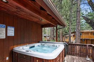 a hot tub on the deck of a house at Arctic Wolf at Summit Base - 4 Bedroom log cabin at the base of Snow Summit in Big Bear Lake