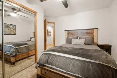a bedroom with a bed and a mirror at Arctic Wolf at Summit Base - 4 Bedroom log cabin at the base of Snow Summit in Big Bear Lake