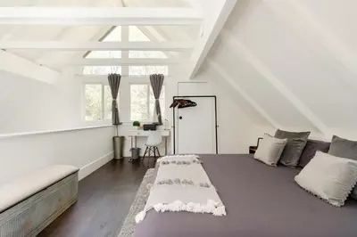 a bedroom with a large bed in a attic at Sprocket Hollow Treetop A-Frame Log Cabin in Cedar Glen