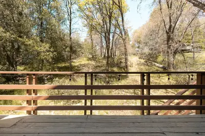 a wooden bridge with a view of a forest at Sprocket Hollow Treetop A-Frame Log Cabin in Cedar Glen