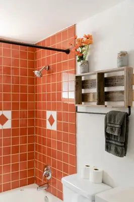 a bathroom with a toilet and a shower with orange tile at Sprocket Hollow Treetop A-Frame Log Cabin in Cedar Glen