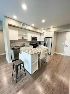 a kitchen with white cabinets and a table and chairs at Glamorous Getaway in Hollywood in Los Angeles
