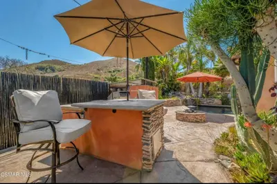 a patio with a table and an umbrella and a chair at Emeric Ave in Simi Valley in Simi Valley