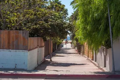 an empty street with trees and a fence at Sunny Studio in the Heart of Venice Beach - #6 in Los Angeles