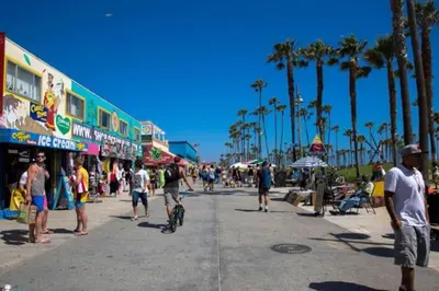 a group of people walking down a street with palm trees at Sunny Studio in the Heart of Venice Beach - #6 in Los Angeles