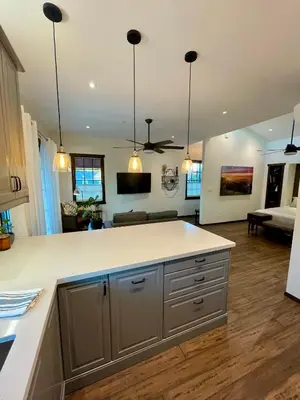 a kitchen with white counter tops and a living room at Cozy Guesthouse with Rooftop Deck in Los Angeles
