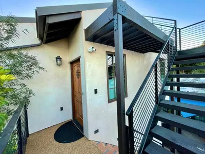a staircase leading up to a house with a door at Cozy Guesthouse with Rooftop Deck in Los Angeles