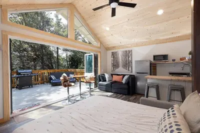a bedroom with a bed and a kitchen and a living room at One With Nature in Crest Park