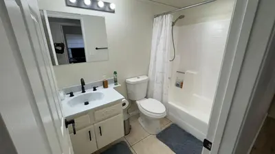 a bathroom with a toilet and a sink and a mirror at Oasis Home near Rancho Vista in Quartz Hill
