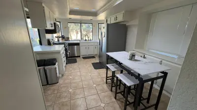 a kitchen with a table and some chairs in it at Oasis Home near Rancho Vista in Quartz Hill