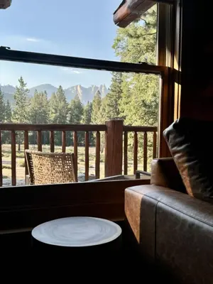 a living room with a couch and a large window at Peppermint Falls Ranch in Ponderosa