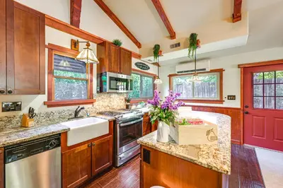 a kitchen with wooden cabinets and a red door at Idyllic Home in Kernville with Private Beach Access in Kernville