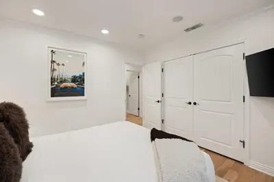 a white living room with a couch and a tv at Belmont Beverly Hills by Stay Awhile Villas in Los Angeles