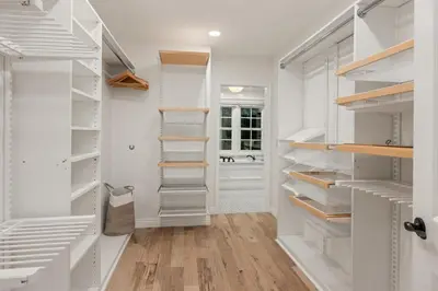 a white walk in closet with wooden shelves at Belmont Beverly Hills by Stay Awhile Villas in Los Angeles