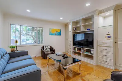 a living room with a blue couch and a tv at Cozy Home with Pool and Jacuzzi Minutes from Universal Studios in Los Angeles