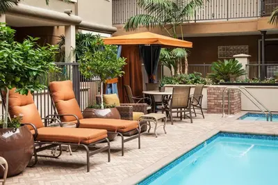 a patio with chairs and a pool and a table at Charming 1BD with Pool and Free Parking in Los Angeles
