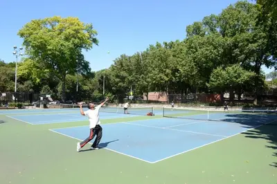 a man serving a tennis ball on a tennis court at Charming Home Near Six Flags in Santa Clarita