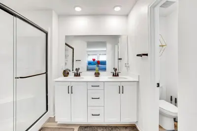 a white bathroom with two sinks and a mirror at Charming Home Near Six Flags in Santa Clarita