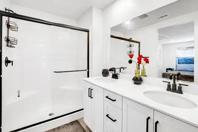 a white bathroom with two sinks and a shower at Charming Home Near Six Flags in Santa Clarita