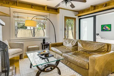 a living room with a couch and a table at Walk to Abbot Kinney Tranquil Cottage in Venice! in Los Angeles