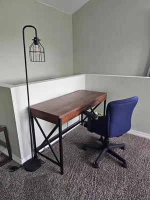 a wooden desk with a blue chair and a lamp at Spacious 2 story 1 bedroom home with pool in Rio Bravo