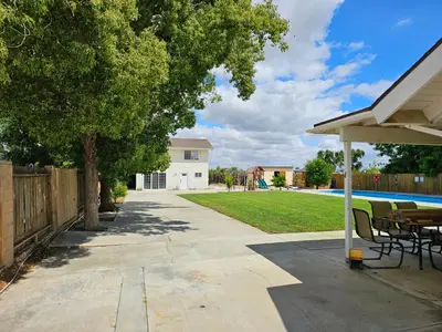 a patio with a table and chairs in a yard at Spacious 2 story 1 bedroom home with pool in Rio Bravo